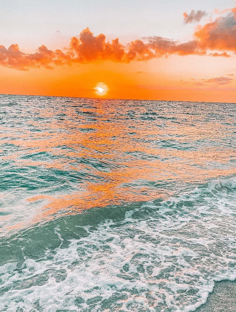una puesta de sol sobre el océano con olas Fondos de pantalla