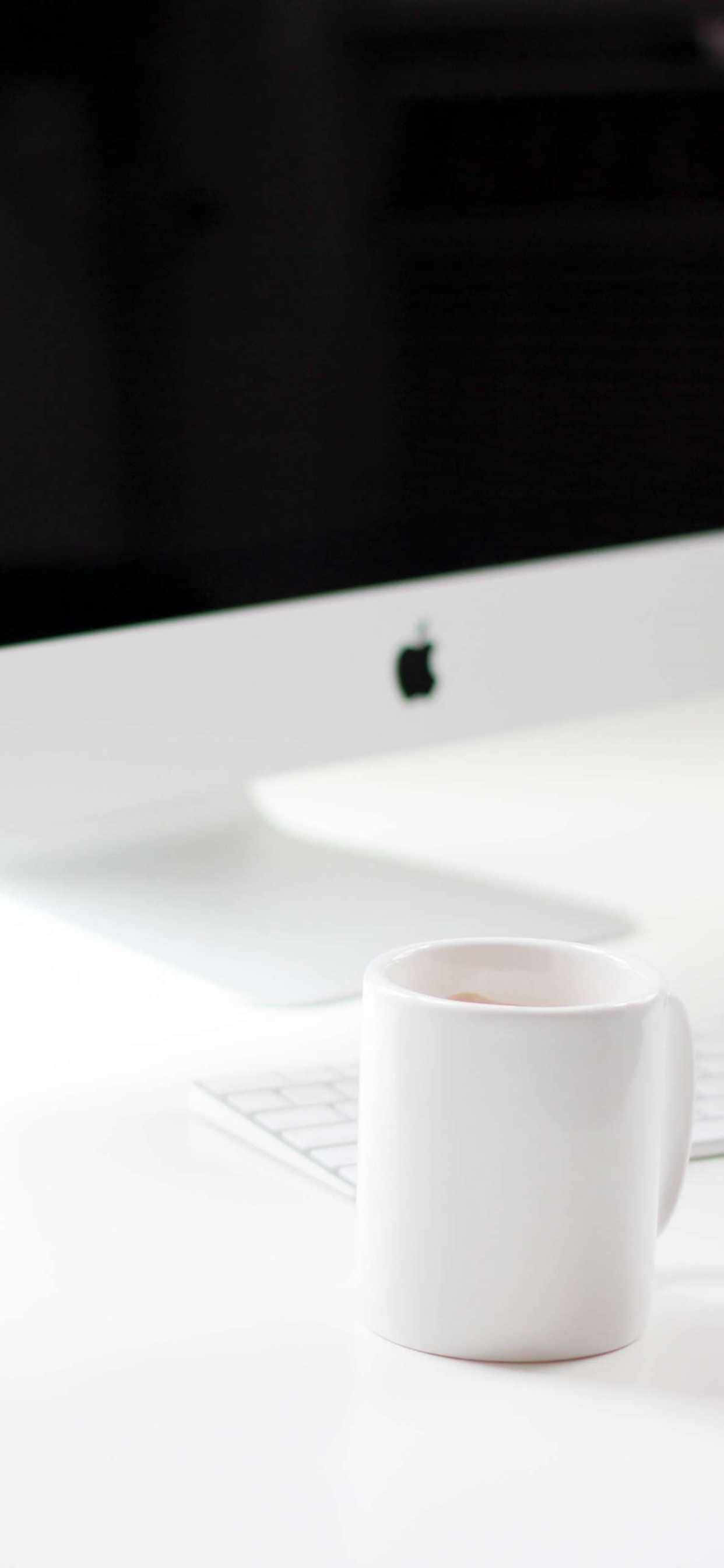 una taza blanca sobre un escritorio Fondos de pantalla