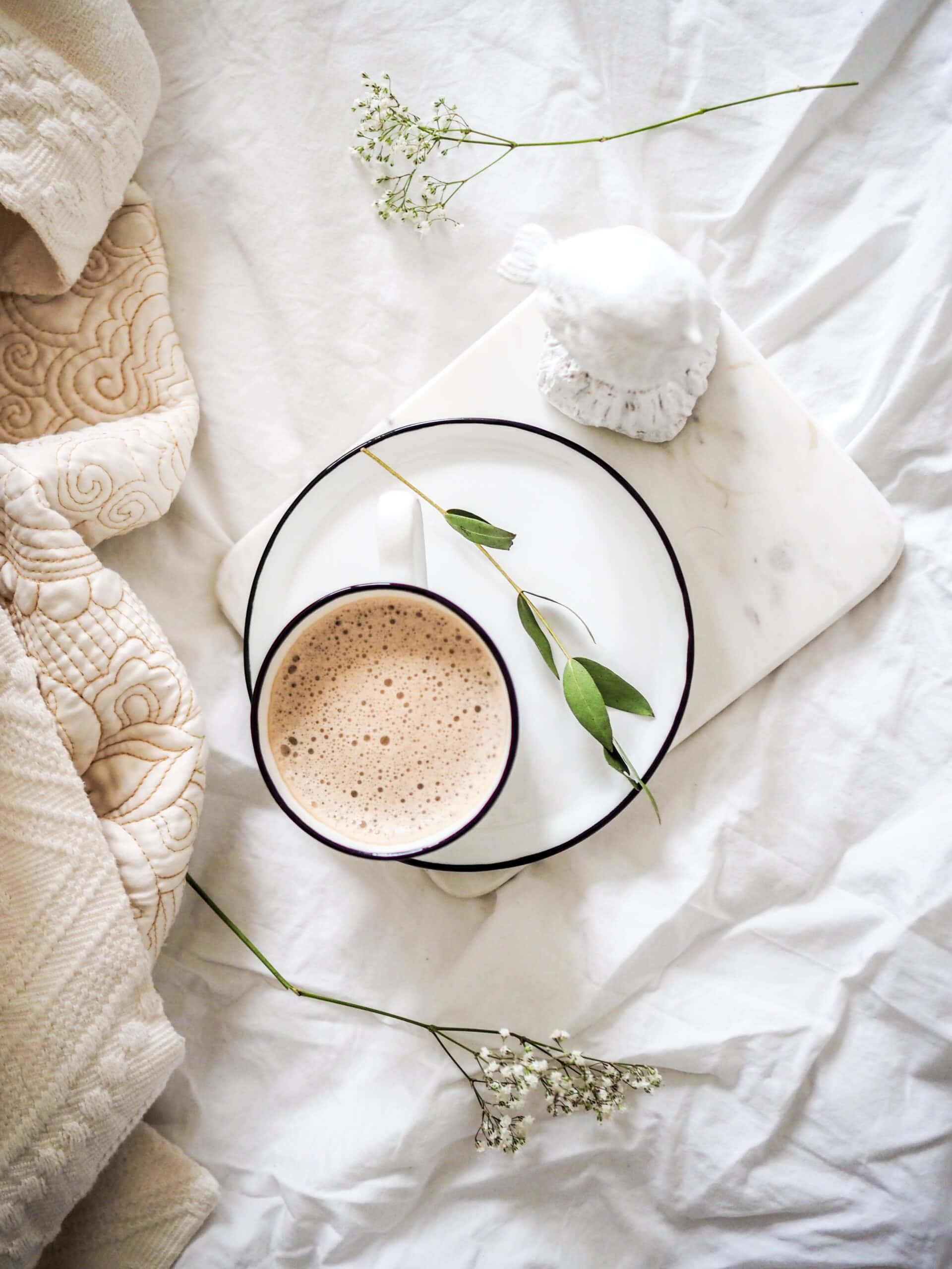una taza de café sobre una cama con flores Fondos de pantalla