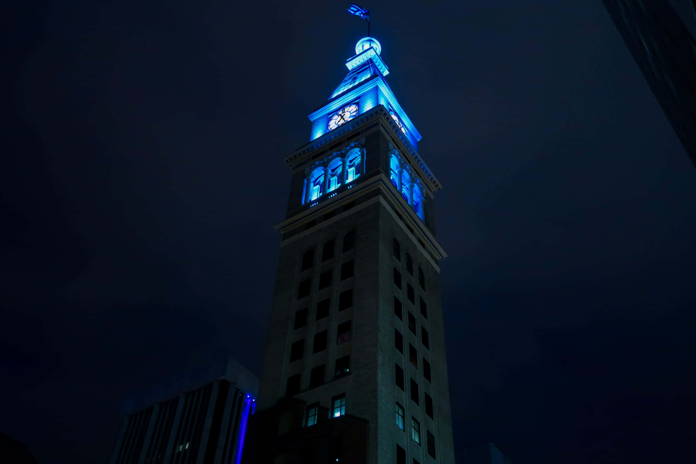 Una torre de reloj iluminada por la noche Fondos de pantalla