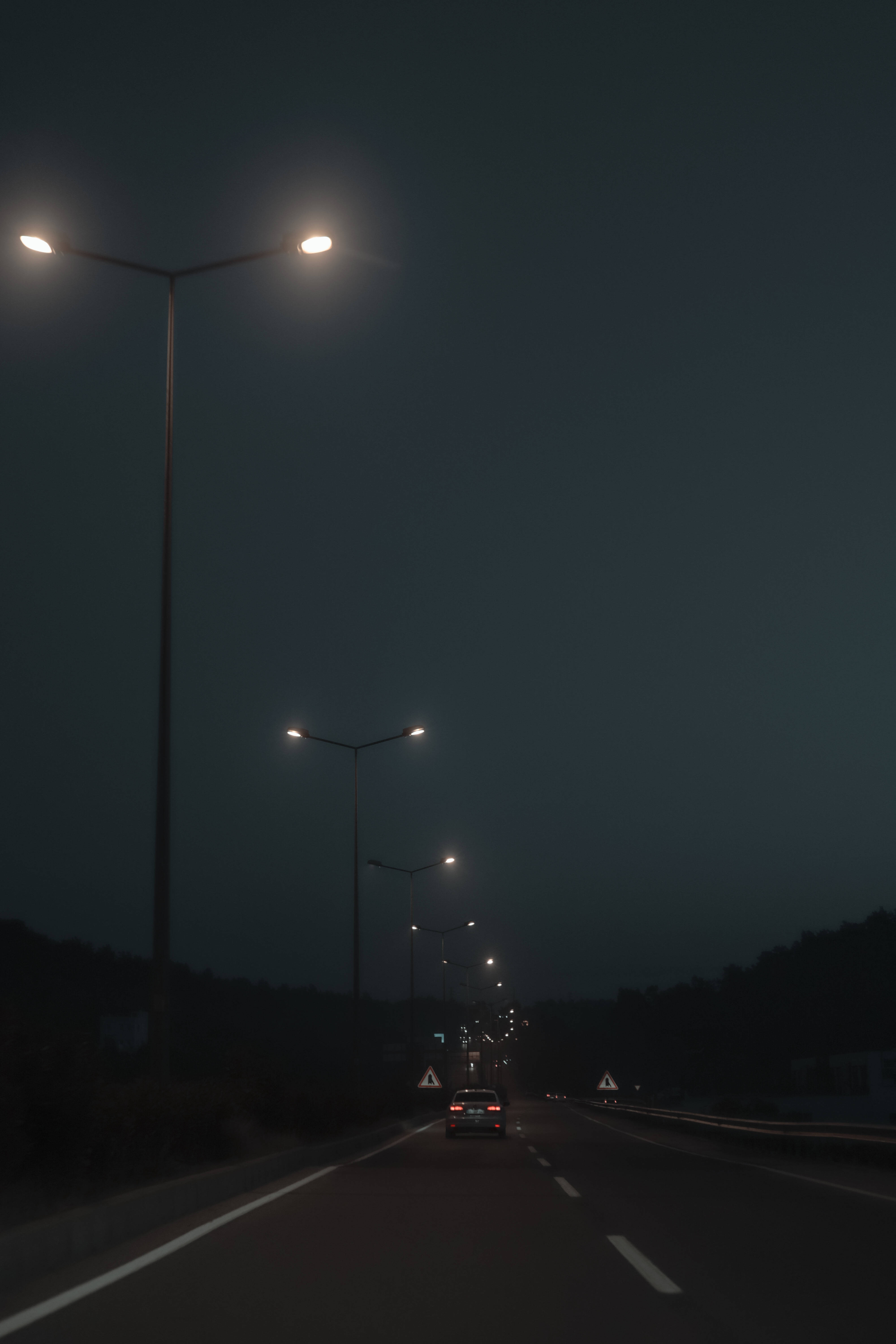 Viejas farolas junto a la carretera en un atardecer tenue Fondos de pantalla