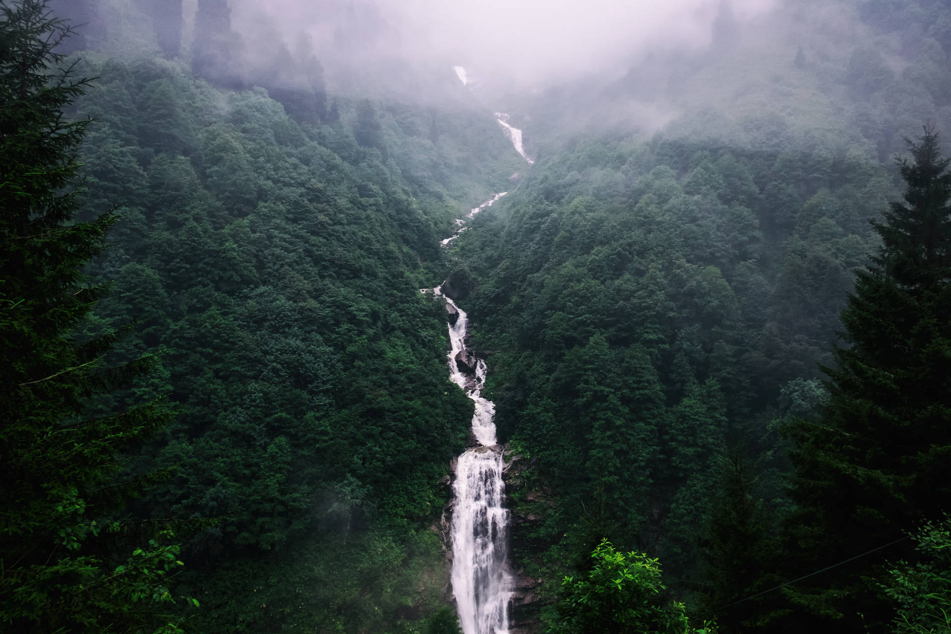 Fondo de pantalla de una toma aérea de una larga cascada.