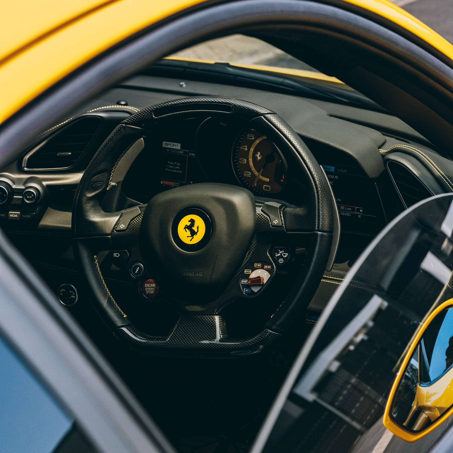Fondo de pantalla de escritorio del interior de un Ferrari con volante, velocímetro y logotipo.