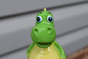 Vista frontal de un lindo dinosaurio de juguete — Dinosaurio lindo Fondos de pantalla