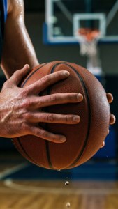 Toma en primer plano de manos sosteniendo un balón de baloncesto con enfoque intenso y sudor. — Baloncesto Fondos de pantalla