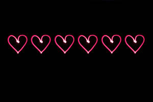 Corazones rosas neón dibujados sobre un fondo negro para el Día de San Valentín. Arte digital para tu amor.