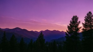 Un atardecer impresionante con tonos púrpura sobre las montañas, ideal para los amantes de la naturaleza. — Morado Fondos de pantalla