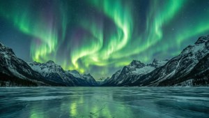 Una hermosa aurora boreal verde ilumina el cielo nocturno sobre montañas nevadas. — Cielo verde Fondos de pantalla