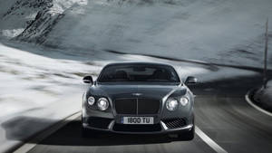 Fondo de pantalla Bentley acelerando en montañas nevadas — Chromebook Fondos de pantalla