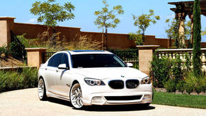 Fondo de pantalla de un BMW Serie 7 F01 blanco con tuning Asanti en la entrada