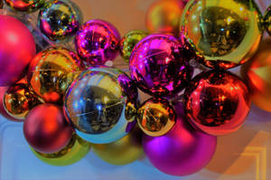 Fondo de pantalla de bolas decorativas navideñas en rosa, dorado y azul.