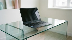 Una escena limpia y minimalista con un Chromebook sobre una mesa de vidrio.