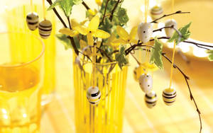 Huevos de Pascua con cáscaras pintadas en diseño de lunares y rayas en un jarrón amarillo, fondo de pantalla de Pascua.
