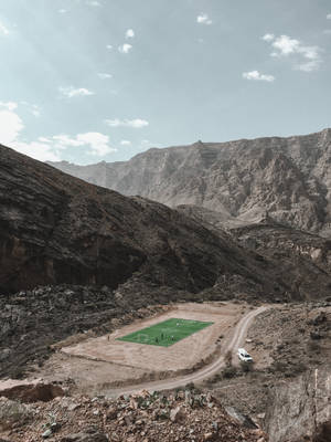 Fondo de pantalla de estadio de fútbol en la cordillera visto desde arriba.