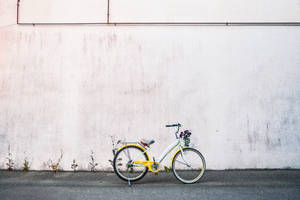 Bici Urbana Amarilla cerca de una pared blanca. — Amanecer Fondos de pantalla