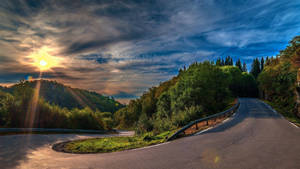 Atardecer brillante en una carretera despejada llena de árboles.