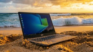 Un Chromebook descansando en una playa de arena durante una impresionante puesta de sol.