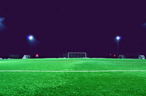 Fondo de pantalla de estadio de fútbol de noche con cielo oscuro.