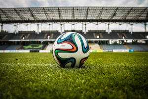 Fondo de pantalla de escritorio de estadio de fútbol, balón de fútbol y césped verde.