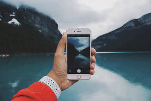 persona tomando foto de un lago — iPhone 8 Fondos de pantalla