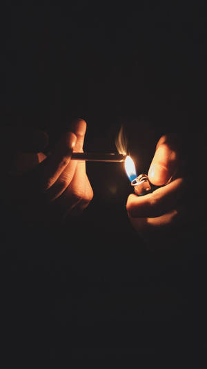 Fondo de pantalla para iPhone de un cigarro encendido en la oscuridad