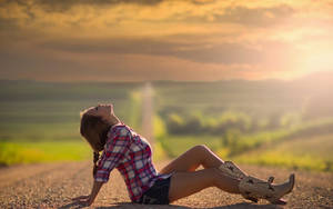 Fondo de pantalla de una hermosa chica campestre recostada en medio de la calle