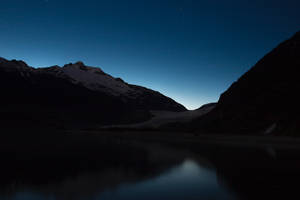 Lago de montaña con cima negra durante la noche.