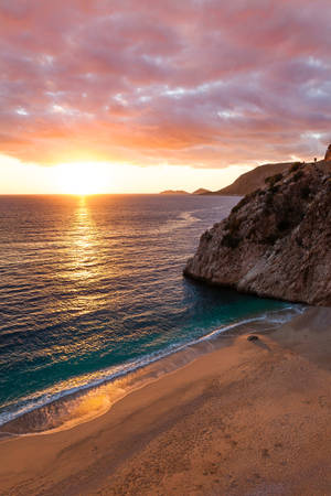 Costa oceánica con una gran roca en las aguas. Vista del atardecer en el mar.