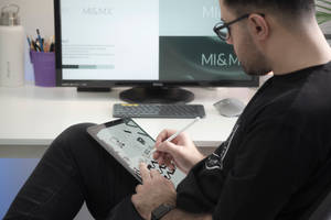 hombre con camisa de manga larga negra sentado junto a un monitor de pantalla plana negro — iPad Mini Fondos de pantalla
