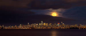 Vista ultraancha de la ciudad desde lejos con luna amarilla sobre un cielo oscuro y sombrío. — 2560x1080 Fondos de pantalla