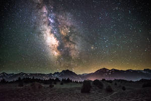 Fondo de pantalla de noche estrellada sobre montañas
