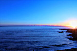 Océano azul y cielo mostrando el horizonte durante el atardecer.