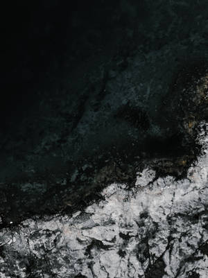 Orilla del océano con hielo y agua azul oscuro salpicando.