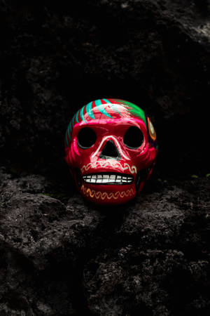 Calavera pintada con pintura roja y verde mostrando arte cultural.