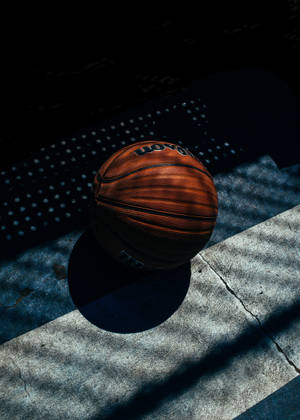 Fondo de pantalla de un balón de baloncesto sobre concreto con sombras rayadas — OnePlus Pad 2 Pro Fondos de pantalla