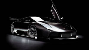 Fondo de pantalla de auto impresionante de un Lamborghini negro con puertas de ala.