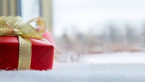 Primer plano elegante de un regalo navideño rojo y dorado en un alféizar nevado. — Regalos de Navidad Fondos de pantalla