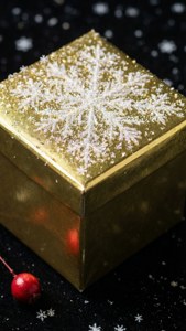 Brillante regalo dorado con copos de nieve sobre superficie negra con baya. — iPhone 7 Fondos de pantalla