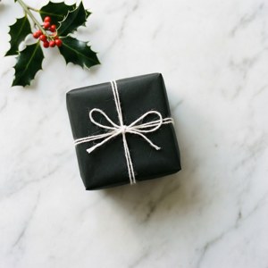 Sencillo regalo en blanco y negro con acebo sobre superficie de mármol. — Regalos de Navidad Fondos de pantalla
