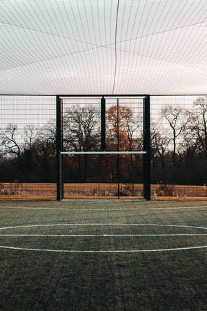Fondo de pantalla móvil de campo de fútbol cerrado en un día brillante.