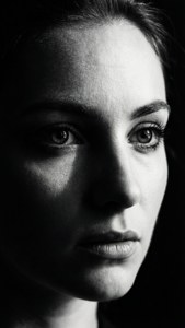 Retrato en blanco y negro con sombras dramáticas y ojos intensos.