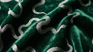 Terciopelo verde oscuro con patrones de serpientes plateadas para un fondo de pantalla de estética Slytherin lujosa.