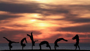 Silueta cayendo al atardecer en la playa — Atardecer en la playa Fondos de pantalla