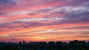 Un cielo colorido al amanecer sobre la silueta del horizonte de la ciudad. — Vista del cielo Fondos de pantalla