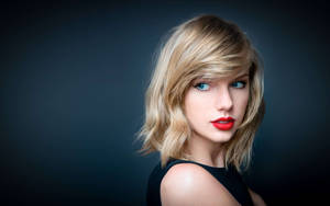 Taylor Swift luce impresionante con cabello rubio y ojos azul verdosos fondo de pantalla.