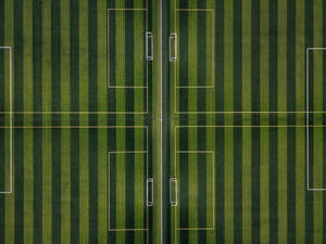 Fondo de escritorio de campo de fútbol rayado verde.