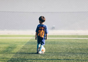 Fondo de pantalla de escritorio de niño aficionado al fútbol con camiseta de Lionel Messi.