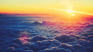 Fondo de pantalla de amanecer amarillo anaranjado sobre un mar de nubes