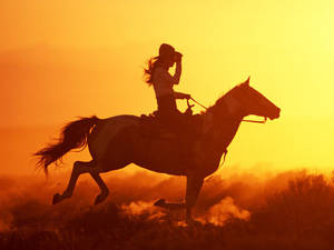 Vaqueros Cabalgando Hacia el Atardecer