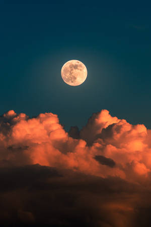 Luna y nubes naranjas en un cielo azul de medianoche. Hermosa vista escénica nocturna desde arriba.